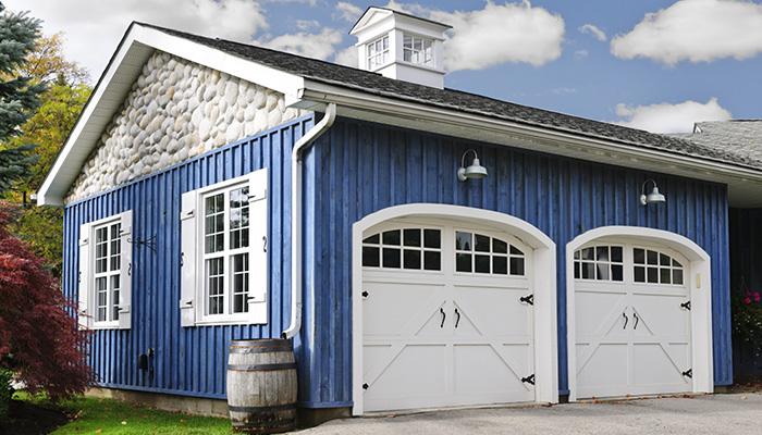 Blue Home With Dual White Garage Doors
